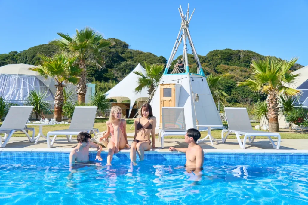 OASIS-OARAIのプールで4人のゲストが水辺で会話とリラックスを楽しんでいる様子。