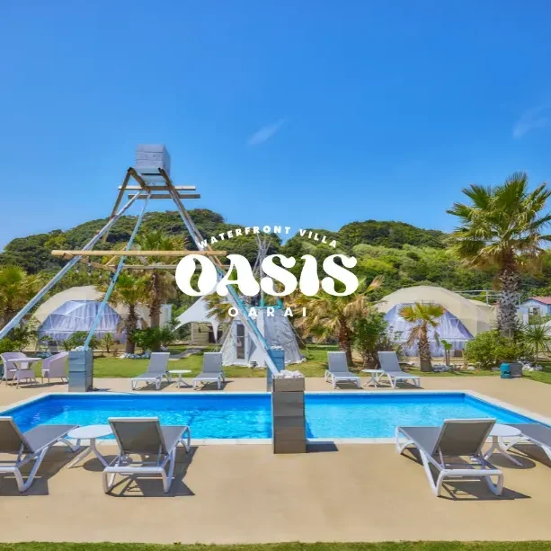 晴天の下、OASIS-OARAIのプールとティピー・ドーム型宿泊棟が並ぶラグジュアリーな屋外空間。
