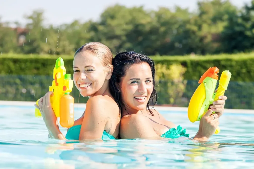 プールで遊ぶ水鉄砲のイメージ - 茨城・大洗ひたちなかエリアのグランピング施設 Water front Villa OASIS大洗 プールで水鉄砲を構える二人の後ろ姿