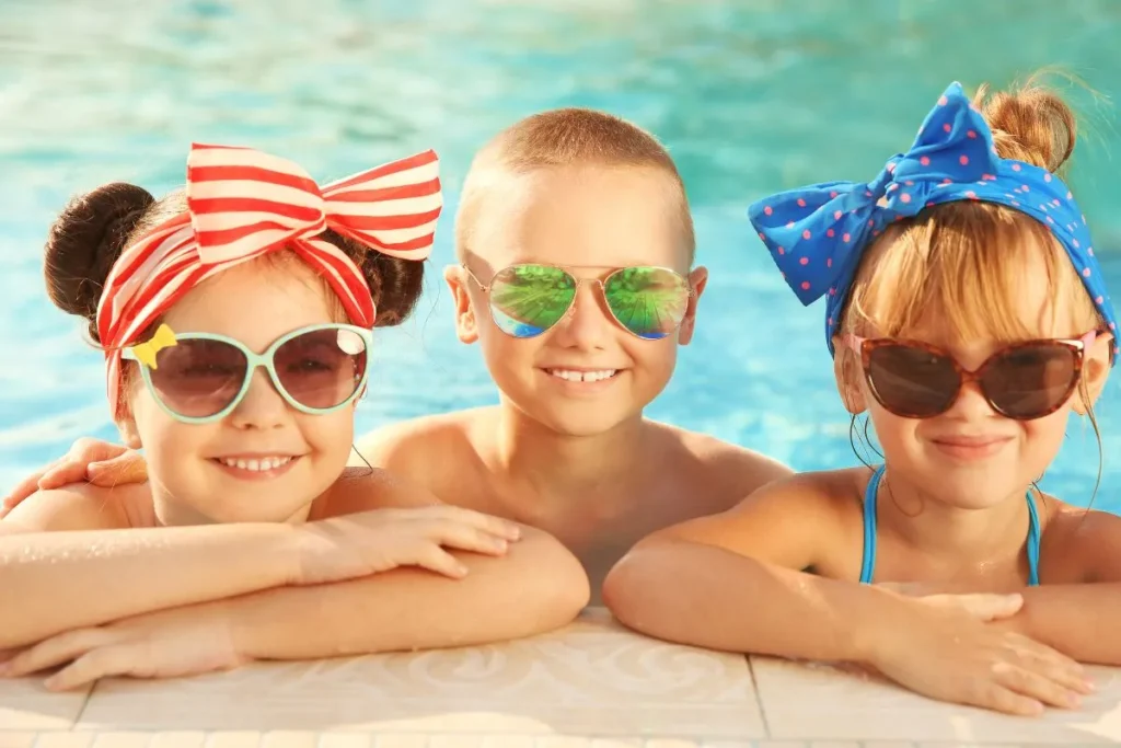 プールサイドでサングラスをかけた子どもたち - 茨城・大洗ひたちなかエリアのグランピング施設 Water front Villa OASIS大洗 プールサイドでサングラスをかけて並ぶ三人の子ども