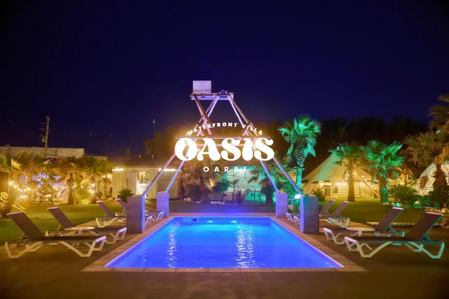 「OASIS-OARAI|ライトアップされたプールとドームテントの夜景」 - 茨城・大洗ひたちなかエリアのグランピング施設 Water front Villa OASIS大洗 ライトアップされたプールとドームテントが並ぶOASIS-OARAIのナイトリゾート風景