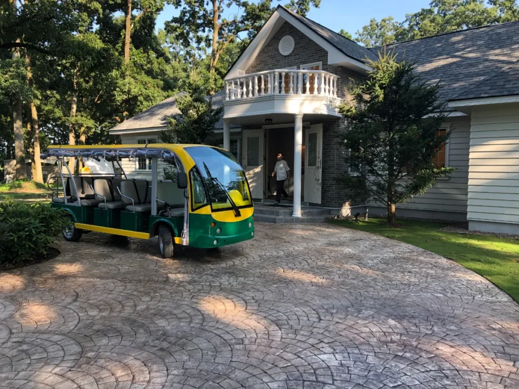 芳賀ファームグランピング|クラブハウスと送迎カート - 茨城・大洗ひたちなかエリアのグランピング施設 Water front Villa OASIS大洗 「芳賀ファームグランピングのクラブハウス前に停まる送迎カートと石畳のエントランス